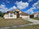 Inviting single-story home with a two-car garage, set against a backdrop of a bright sky and lush greenery at 4526 Oakton Dr, Orlando, FL 32818