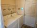 Functional laundry area featuring a washer, dryer, shelving, and a door to the outside at 4526 Oakton Dr, Orlando, FL 32818