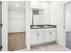 Elegant bathroom featuring double sinks, modern cabinetry and a doorway to the walk-in closet at 4701 Jasmine Cir, Leesburg, FL 34748