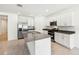 Bright kitchen features stainless appliances, large island with sink, and white cabinetry at 4701 Jasmine Cir, Leesburg, FL 34748