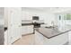 Bright kitchen features stainless appliances, large island with sink, and white cabinetry at 4701 Jasmine Cir, Leesburg, FL 34748