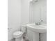 A bright half bathroom features a pedestal sink, toilet, and a large mirror at 4705 Jasmine Cir, Leesburg, FL 34748
