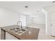 A kitchen island with a stainless steel sink and faucet in a light-filled home at 4705 Jasmine Cir, Leesburg, FL 34748