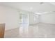 Bright, open-concept living room with tile flooring and sliding glass door to the backyard at 4705 Jasmine Cir, Leesburg, FL 34748