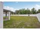 Backyard of home featuring a white fence and green lawn at 4721 Jasmine Cir, Leesburg, FL 34748
