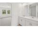Bathroom featuring dual sinks, white cabinetry, and an open view to the bedroom at 4721 Jasmine Cir, Leesburg, FL 34748