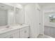 Bright bathroom with dual sinks, white cabinetry, and tile flooring at 4721 Jasmine Cir, Leesburg, FL 34748