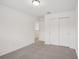 This carpeted bedroom offers neutral walls and a double door closet at 4721 Jasmine Cir, Leesburg, FL 34748
