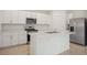 Modern kitchen boasts stainless steel appliances, white cabinetry, and an island with a sink at 4721 Jasmine Cir, Leesburg, FL 34748