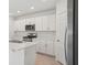 Bright kitchen features stainless steel appliances, white cabinetry, and a large island with a breakfast bar at 4721 Jasmine Cir, Leesburg, FL 34748
