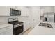 Modern kitchen featuring stainless steel appliances, white cabinets, and quartz countertops at 4721 Jasmine Cir, Leesburg, FL 34748