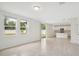 Open living area with windows, tile floors, leading to the kitchen with stainless appliances at 4721 Jasmine Cir, Leesburg, FL 34748