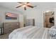 View of a bedroom with a TV, gray walls, carpet, ceiling fan, and a walk-in closet at 4870 Conway Rd # 106, Orlando, FL 32812