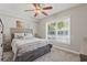 Comfortable bedroom with a ceiling fan, gray carpet, light gray walls, and a large window for natural light at 4870 Conway Rd # 106, Orlando, FL 32812