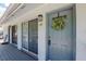 Condo entrance with storm door, door wreath, unit number, lighting fixture and sliding glass door at 4870 Conway Rd # 106, Orlando, FL 32812