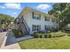 Two-story condo building with lush landscaping, gray shutters, stairway entry, and manicured lawn at 4870 Conway Rd # 106, Orlando, FL 32812
