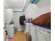 Laundry room with a washer and dryer, white walls, tile floor, and ample shelving for storage at 4870 Conway Rd # 106, Orlando, FL 32812