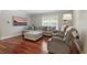 Living room with hardwood floors, large windows, sectional couch, and comfy recliners at 4870 Conway Rd # 106, Orlando, FL 32812