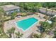 An aerial shot showcases the large community pool area, complete with lounge chairs and palm trees at 4870 Conway Rd # 106, Orlando, FL 32812