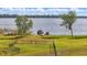 Scenic backyard view featuring a fenced yard, leading to a tranquil lake with a private dock at 521 Sanctuary Blvd, Winter Haven, FL 33881