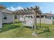 Lush backyard featuring a pergola swing set, creating an inviting outdoor space for relaxation at 521 Sanctuary Blvd, Winter Haven, FL 33881