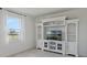 Cozy living room with built-in entertainment center, large window offering natural light, and neutral color scheme at 521 Sanctuary Blvd, Winter Haven, FL 33881