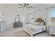 Bright main bedroom featuring a tray ceiling, ample natural light, and stylish decor at 521 Sanctuary Blvd, Winter Haven, FL 33881