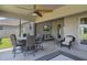 Screened-in patio with outdoor seating and dining overlooking green lawn, and ceiling fan at 521 Sanctuary Blvd, Winter Haven, FL 33881