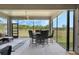Screened-in patio featuring outdoor dining set and comfortable lounge area overlooking the backyard at 521 Sanctuary Blvd, Winter Haven, FL 33881