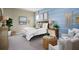 Comfortable bedroom with a blue accent wall, woven headboard, and cozy seating area at 523 Silver Palm Dr, Haines City, FL 33844