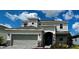 Two-story home featuring a two-car garage, stone accents and manicured landscaping at 523 Silver Palm Dr, Haines City, FL 33844
