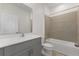 Modern bathroom features a bathtub, shower, vanity with stone countertop, and gray cabinets at 527 Silver Palm Dr, Haines City, FL 33844
