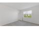 Bright bedroom with plush carpeting and a large window, offering a serene view of the outdoors at 527 Silver Palm Dr, Haines City, FL 33844