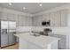 Modern kitchen featuring stainless steel appliances, gray cabinetry, and a center island with a double sink at 527 Silver Palm Dr, Haines City, FL 33844