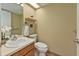 Cozy half bathroom featuring a white toilet and a sink with a wood cabinet at 5330 Keswick Ct, Orlando, FL 32812