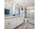 Modern bathroom featuring double sinks, granite countertops, and a glass-enclosed shower at 5416 Solterra Cir, Davenport, FL 33837