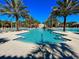 Community pool includes zero entry, waterslide, sun loungers and tropical palm trees at 5416 Solterra Cir, Davenport, FL 33837