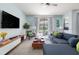 Comfortable living room featuring a large sectional sofa, modern entertainment center and bright windows at 5416 Solterra Cir, Davenport, FL 33837