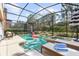 Private screened-in pool and spa area with lounge chairs, umbrella and an inflatable flamingo at 5416 Solterra Cir, Davenport, FL 33837