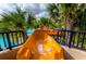 The waterslide winds down to a pool surrounded by beautiful landscaping and palm trees at 5416 Solterra Cir, Davenport, FL 33837