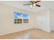 A bright bedroom featuring hardwood floors, a window with clear blue skies, and a ceiling fan at 5763 Saint Christopher Dr # 55, Orlando, FL 32822