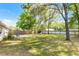 A spacious fenced back yard with mature trees, lush green grass, and a patio area at 5831 Nw 58Th Ter, Ocala, FL 34482