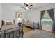 This bedroom features twin beds, a ceiling fan, a window, wood floors, and a decorative rug at 5831 Nw 58Th Ter, Ocala, FL 34482