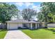 Charming single-story home with a well-maintained lawn, mature trees, and a concrete driveway at 5831 Nw 58Th Ter, Ocala, FL 34482