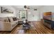 Inviting living room with laminate floors, sectional sofa, ceiling fan, and natural light at 5831 Nw 58Th Ter, Ocala, FL 34482