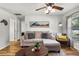 A cozy living room with a sectional sofa, laminate floors, and a ceiling fan at 5831 Nw 58Th Ter, Ocala, FL 34482