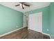 Bedroom featuring light green walls, wood-look floors, ceiling fan, and standard closet at 610 Cranes Way # 207, Altamonte Springs, FL 32701