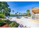 Community pool surrounded by palm trees, lounge chairs, tables, and lush landscaping at 610 Cranes Way # 207, Altamonte Springs, FL 32701