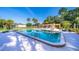 Community swimming pool with a lounge area, tables and chairs with palm trees and clear blue water at 610 Cranes Way # 207, Altamonte Springs, FL 32701