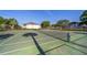 Well-maintained tennis court surrounded by trees and fences with a building in the background at 610 Cranes Way # 207, Altamonte Springs, FL 32701